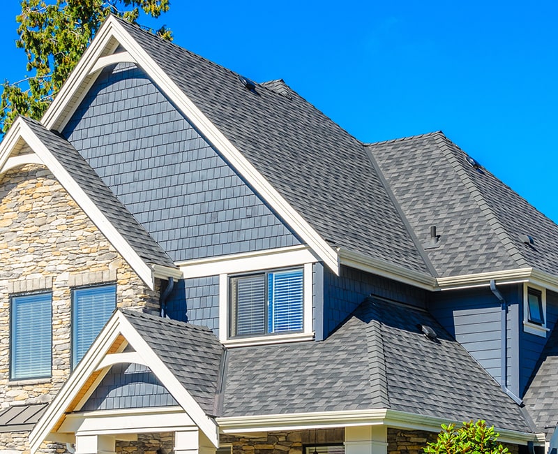 A home roofline with painted blue shingles and white trim 