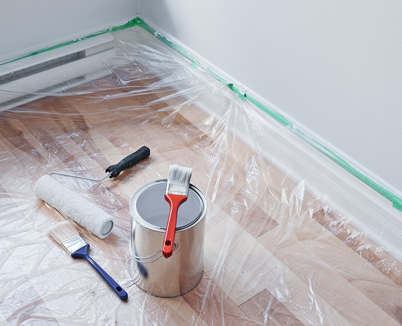 A room is prepared for painting using dropcloths, painters tape and more