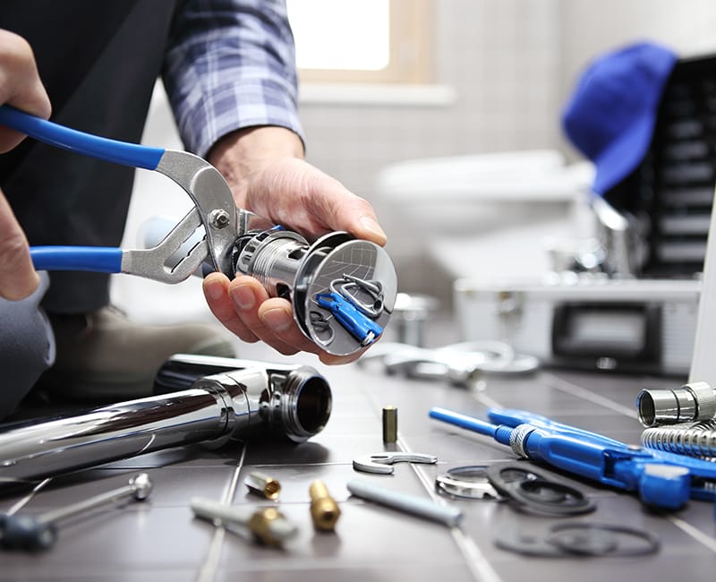 A plumber assembles a new drainline and plumbing fixtures